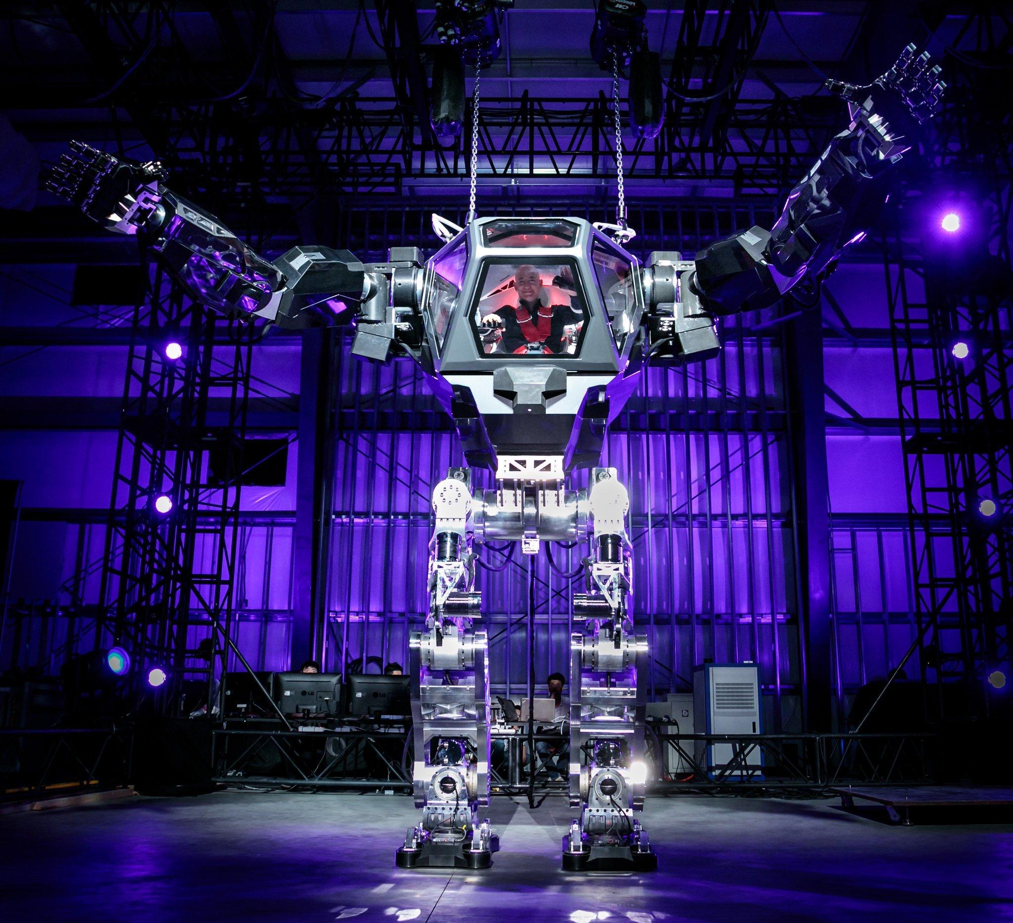 アマゾンのジェフ・ベゾス、ロボットイベントで巨大ロボットを操縦