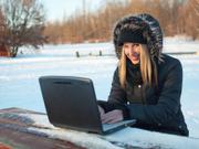 雪景色の中パソコンを使う女性