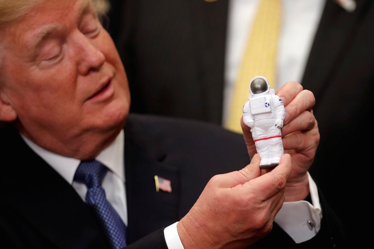宇宙飛行士のおもちゃを手にするトランプ大統領。