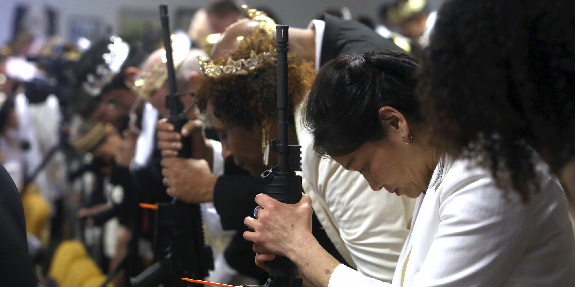 銃を手に礼拝に臨む人々