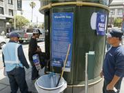 サンフランシスコのミッション・ディストリクトにあるトイレ、ピット・ストップの外に立つ係員。