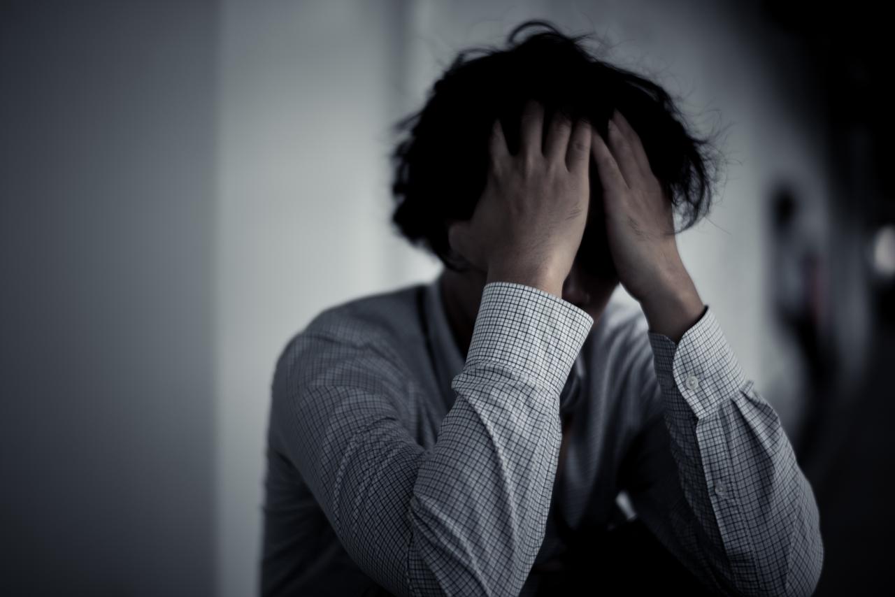 頭を抱える男性。