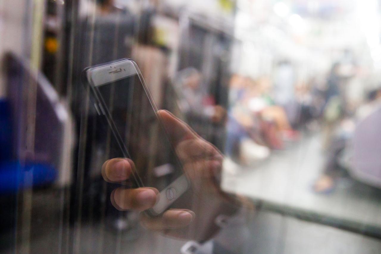窓越しに見えるスマホを持つ片手