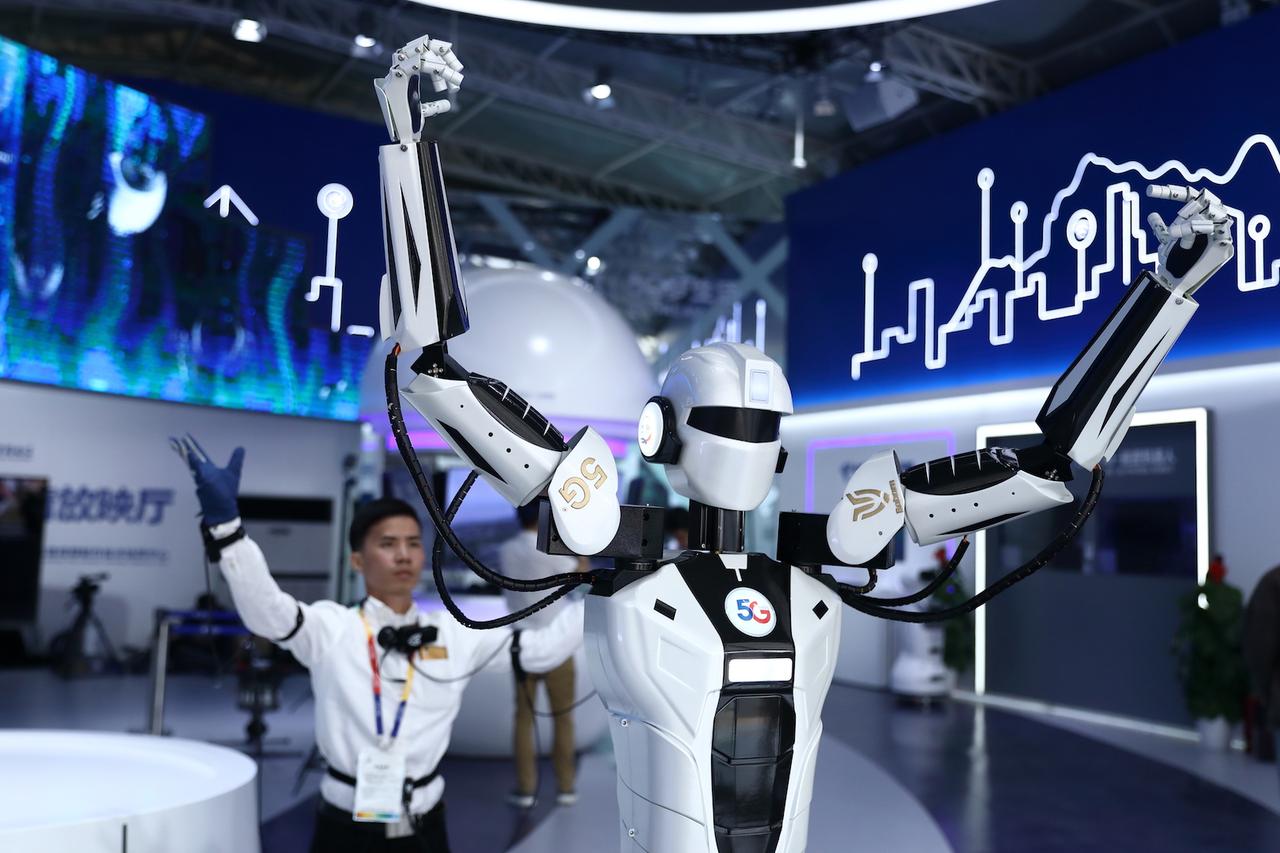 センサー付きのスーツを着た人間の動きを真似るロボット