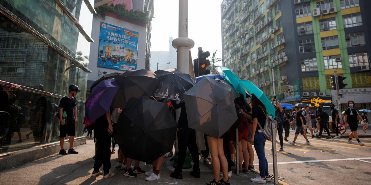 傘を使って身を隠すデモ参加者