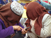 2002年4月、新疆ウイグル自治区のカシュガルで携帯電話を使用しているイスラム教徒の女性。
