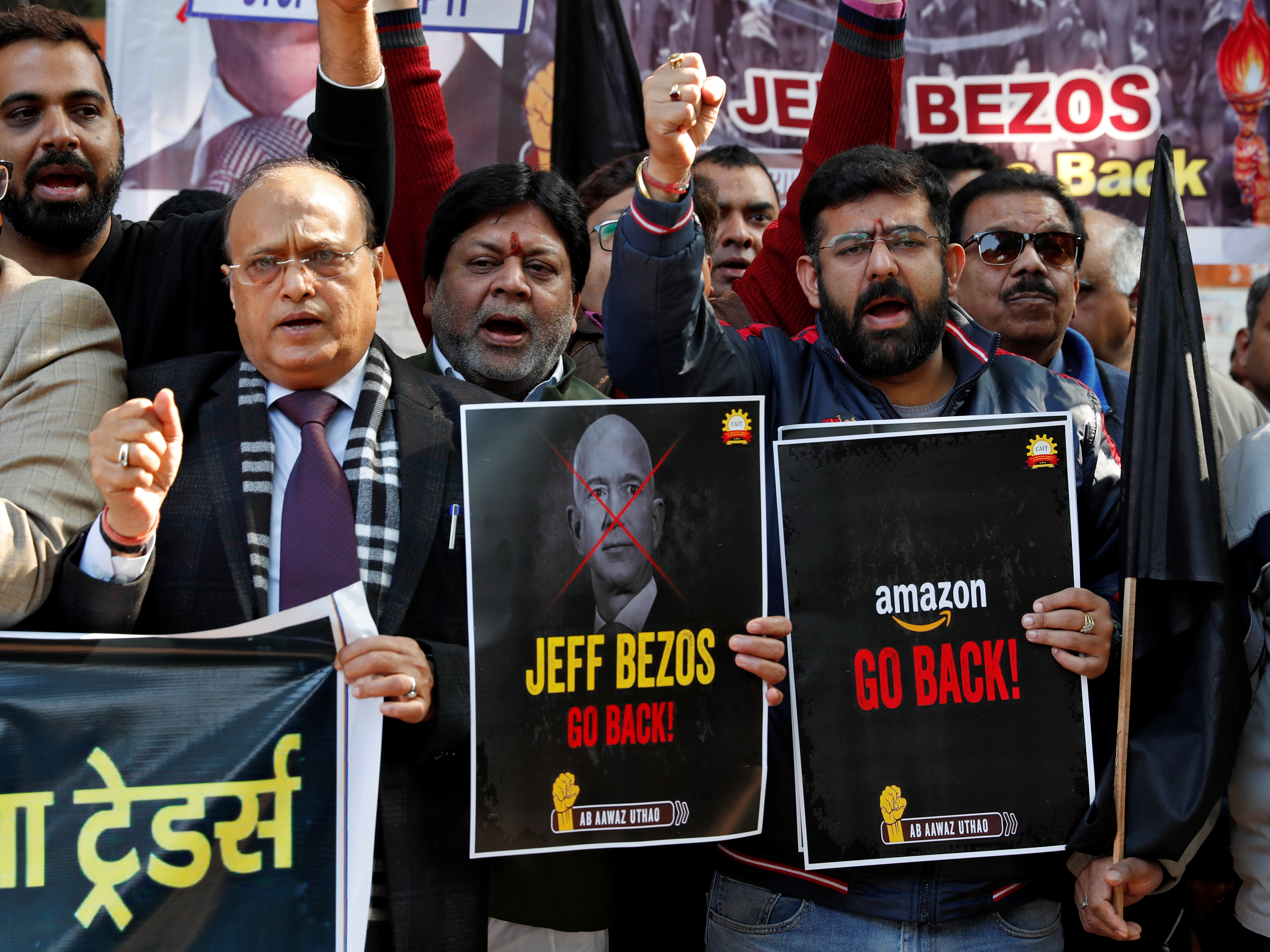 アマゾンのCEOジェフ・ベゾスのインド訪問に抗議して、全インド商業連合（CAIT）のメンバーはプラカードを掲げる。2020年1月15日、インドのニューデリーで。