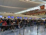 羽田空港でチェックインを待つ人々。春節のため、多くの中国人旅行客が帰省の途につく。