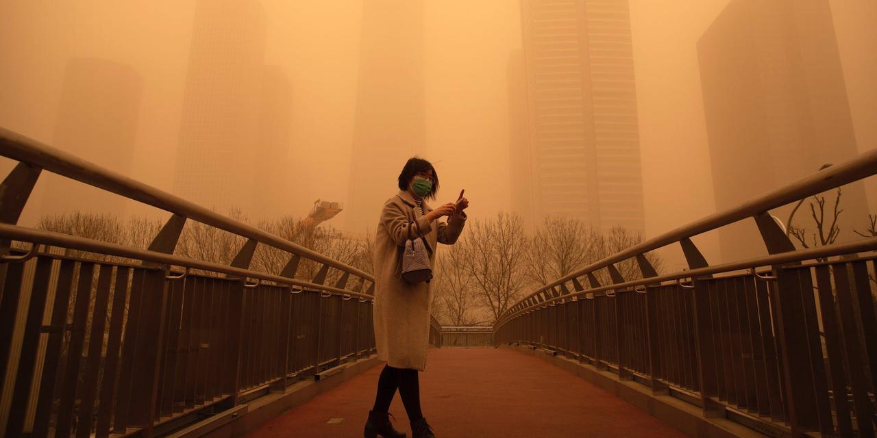 2021年3月15日、北京の朝の通勤時間帯に歩道橋を歩く女性。