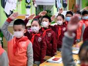 新学期初日に教室で行われた国旗掲揚式に参加する小学生。2021年3月1日、中国・北京で。