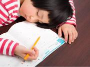 宿題をしながら寝る子ども