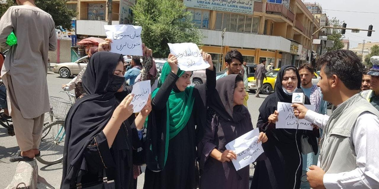 大統領官邸の前で権利保護を求めてプラカードを掲げるアフガニスタンの女性。