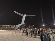 カブール空港から退避する人々。