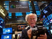 2013年12月23日、ニューヨーク証券取引所で笑顔を見せるトレーダー。