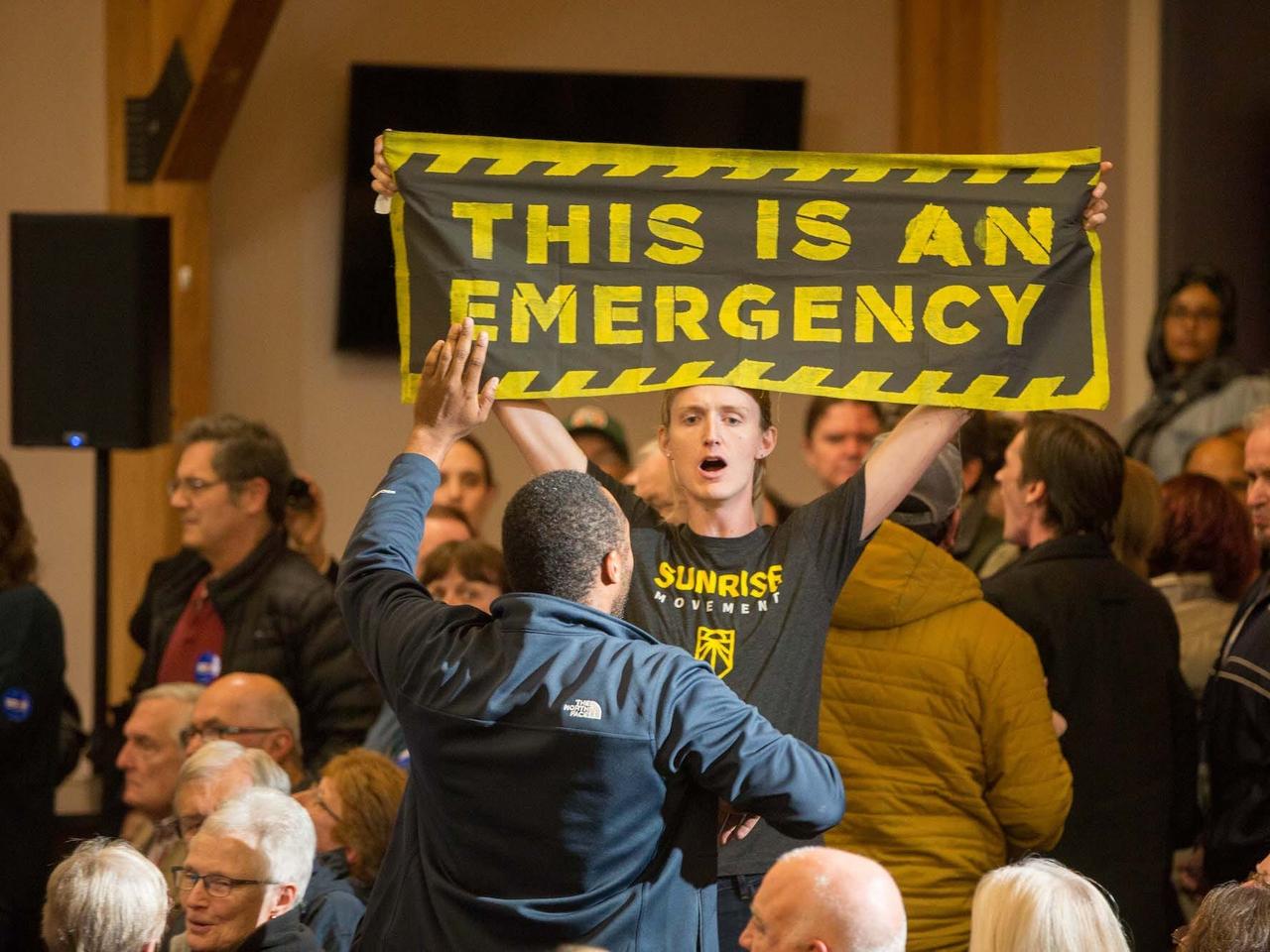 2019年10月9日、ニューハンプシャー州マンチェスターで行われたジョー・バイデン大統領候補（当時）の選挙集会を妨害する気候変動の抗議家。