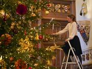 A member of the Royal Collection Trust staff puts the finishing touches to a Christmas tree in St George's Hall at Windsor Castle