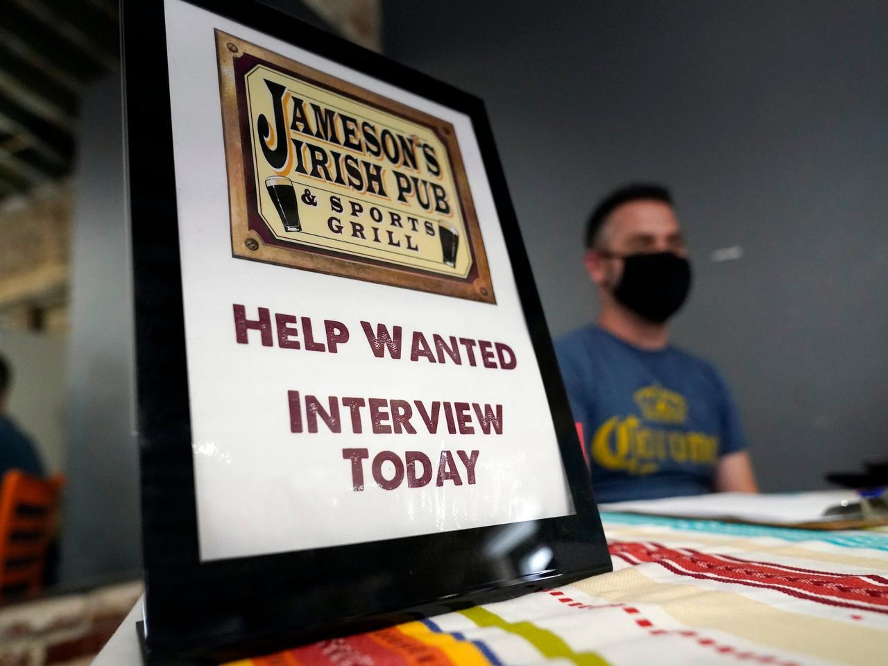  In this Sept. 22, 2021, file photo, a hiring sign is placed at a booth for Jameson's Irish Pub during a job fair in the West Hollywood section of Los Angeles