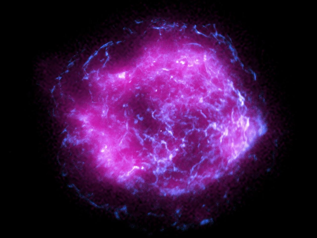 超新星残骸 ｢カシオペアA｣ のこの画像は、X線偏光観測衛星によって収集されたデータ（紫）と、チャンドラX線観測衛星の観測データ（青）を組み合わせたもの。