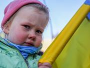 ウクライナとの連帯を示すデモで涙を流す少女。