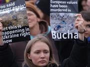 ブチャで殺害された民間人の写真を掲げてロシアの侵攻に抗議する人々。2022年4月6日にドイツのベルリンで。