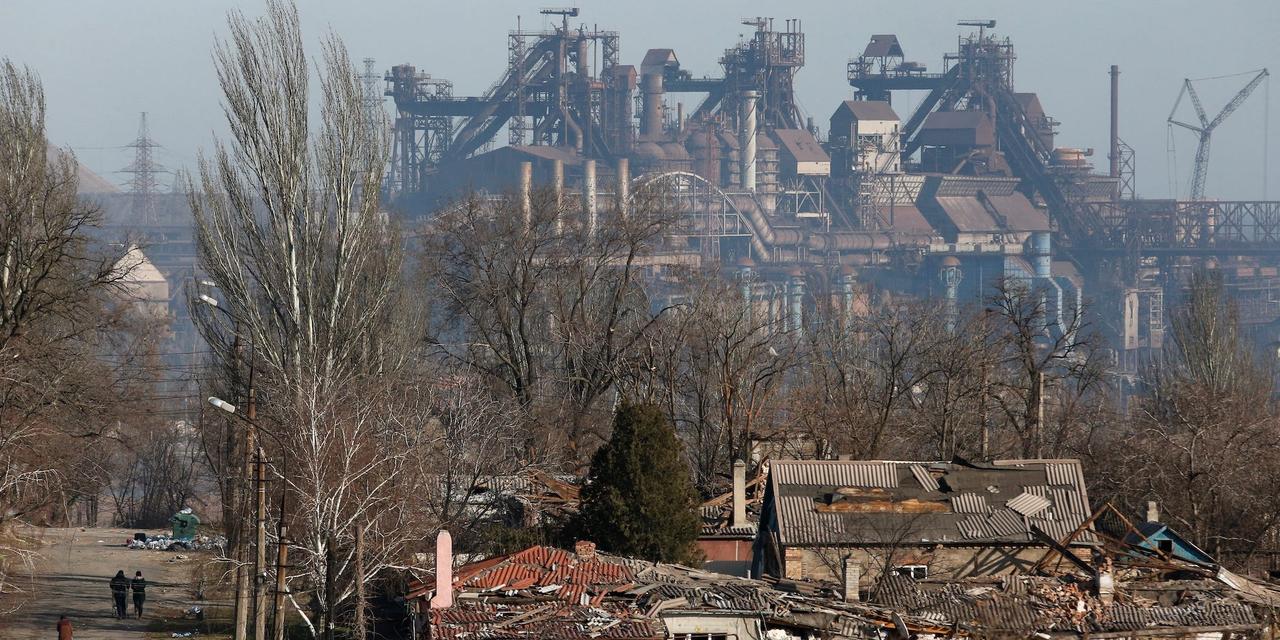 被害を受けた建物の背後に見えるアゾフスタリ製鉄所。ウクライナ・マリウポリで。