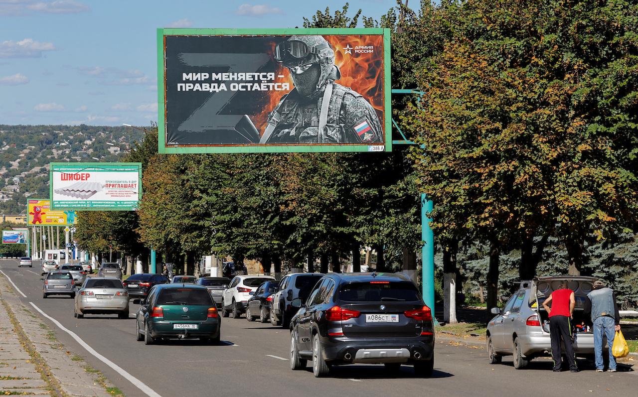 ウクライナ東部のルハンスクの道路沿いにある、親ロシア派のスローガンを表示した広告。ボードの1つにはこう書かれている。｢世界は変わるが、真実は変わらない。ロシア軍｣。2022年9月20日撮影。