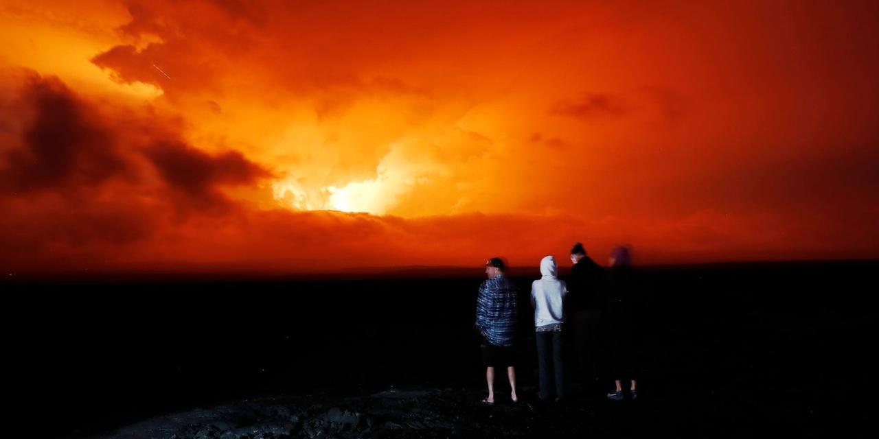 2022年11月28日、ハワイ州ヒロ近郊でマウナロアの噴火を見守る人々。