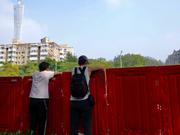 2022年11月11日、中国南部の広東省広州市海珠区に張り巡らされたバリアの反対側を眺める住民たち。