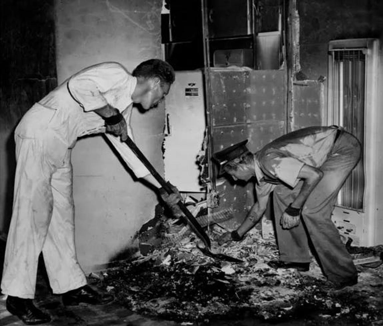  1951年、フロリダのアパートで女性の遺体が発見された現場で、瓦礫をかき集める消防士。