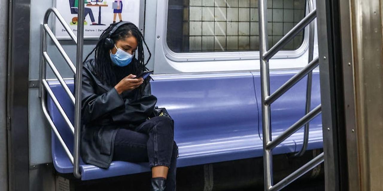 2022 年 10 月 22 日、ニューヨークの地下鉄に乗るマスクをした人。