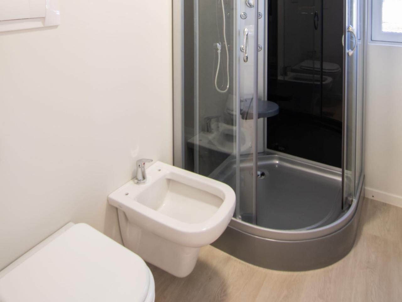 …das Badezimmer hat eine typische Dusche, Waschbecken und Toilette