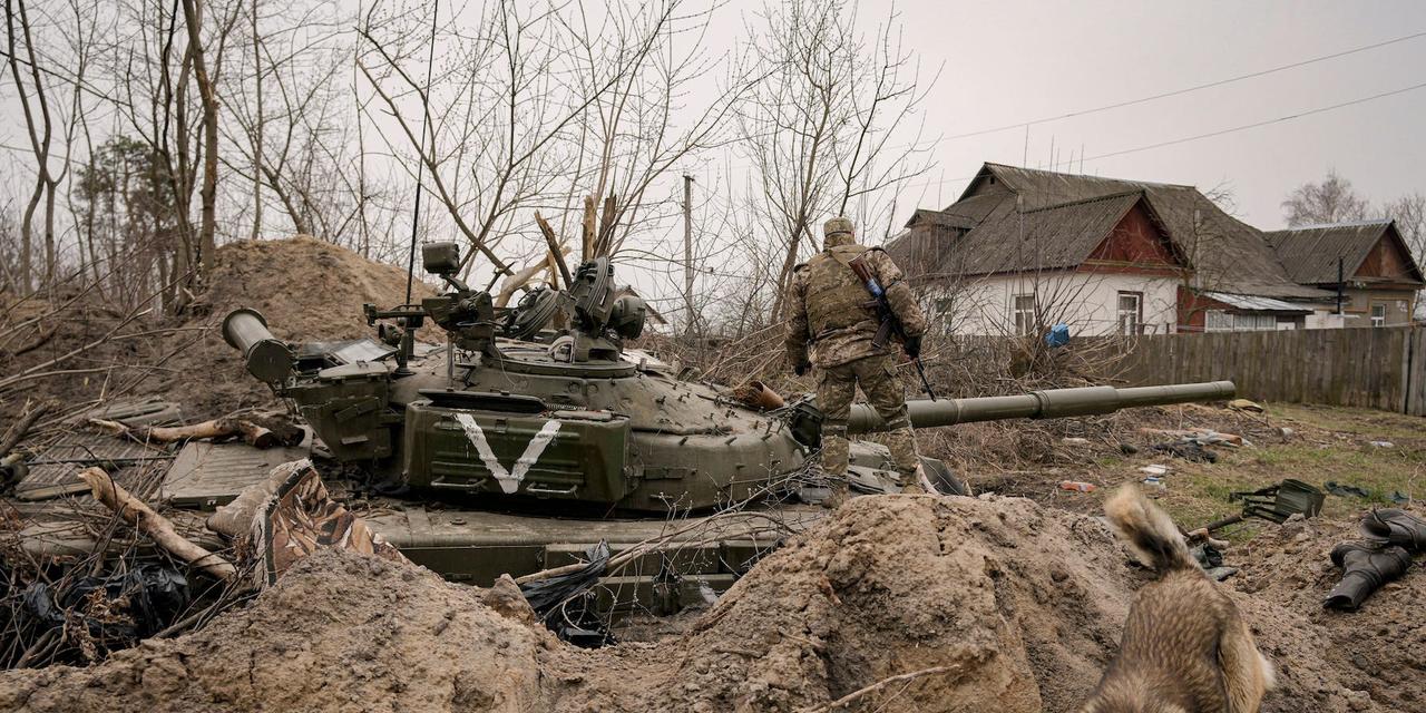 2022年4月5日、ウクライナのアンドリイカで、放棄されたロシア軍の戦車をチェックするウクライナ兵。