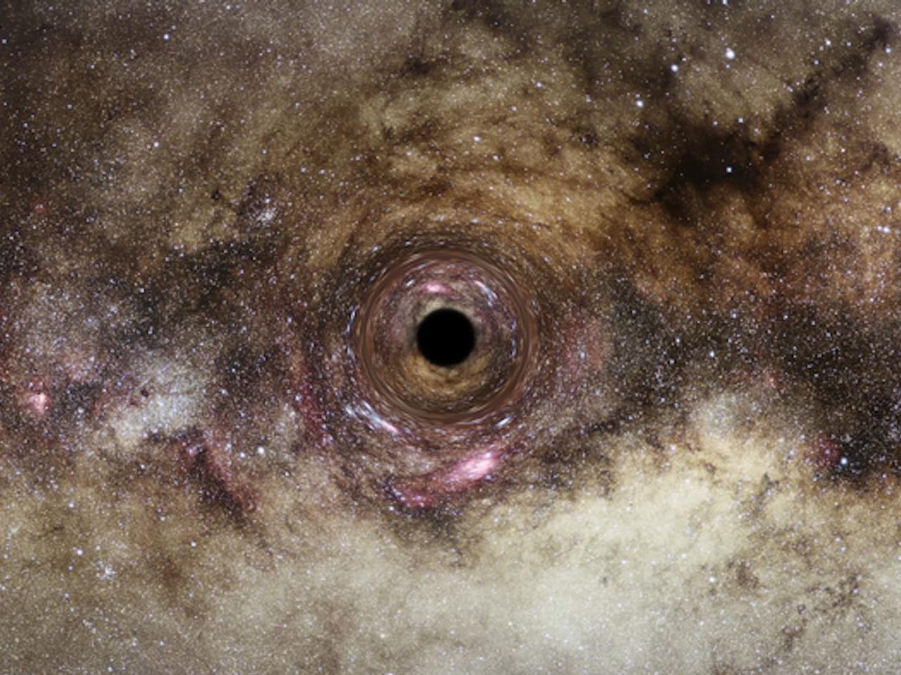 ブラックホールの想像図。観測史上最大級のブラックホールが発見された。この超大質量ブラックホールは、背後にある銀河からの光を歪めてしまうほど強力な重力がある。