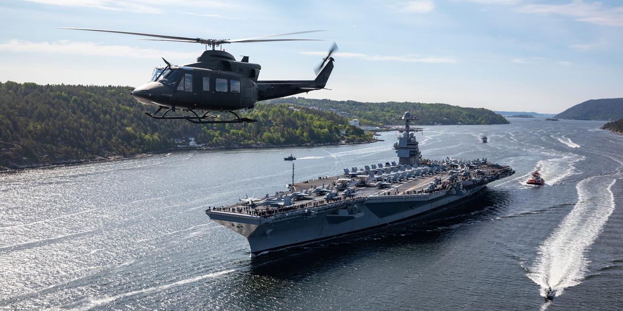 2023年5月24日、オスロのフィヨルドでノルウェー軍の艦艇やヘリコプターと並んで航行するアメリカの空母ジェラルド・R・フォード。