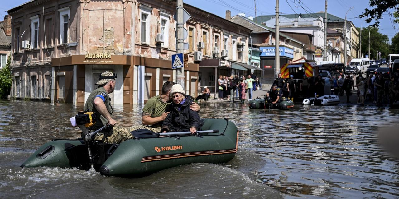 2023年6月7日、ウクライナのへルソンにあるカホフカ・ダムの決壊により浸水した街で、住民を避難させる救援隊。