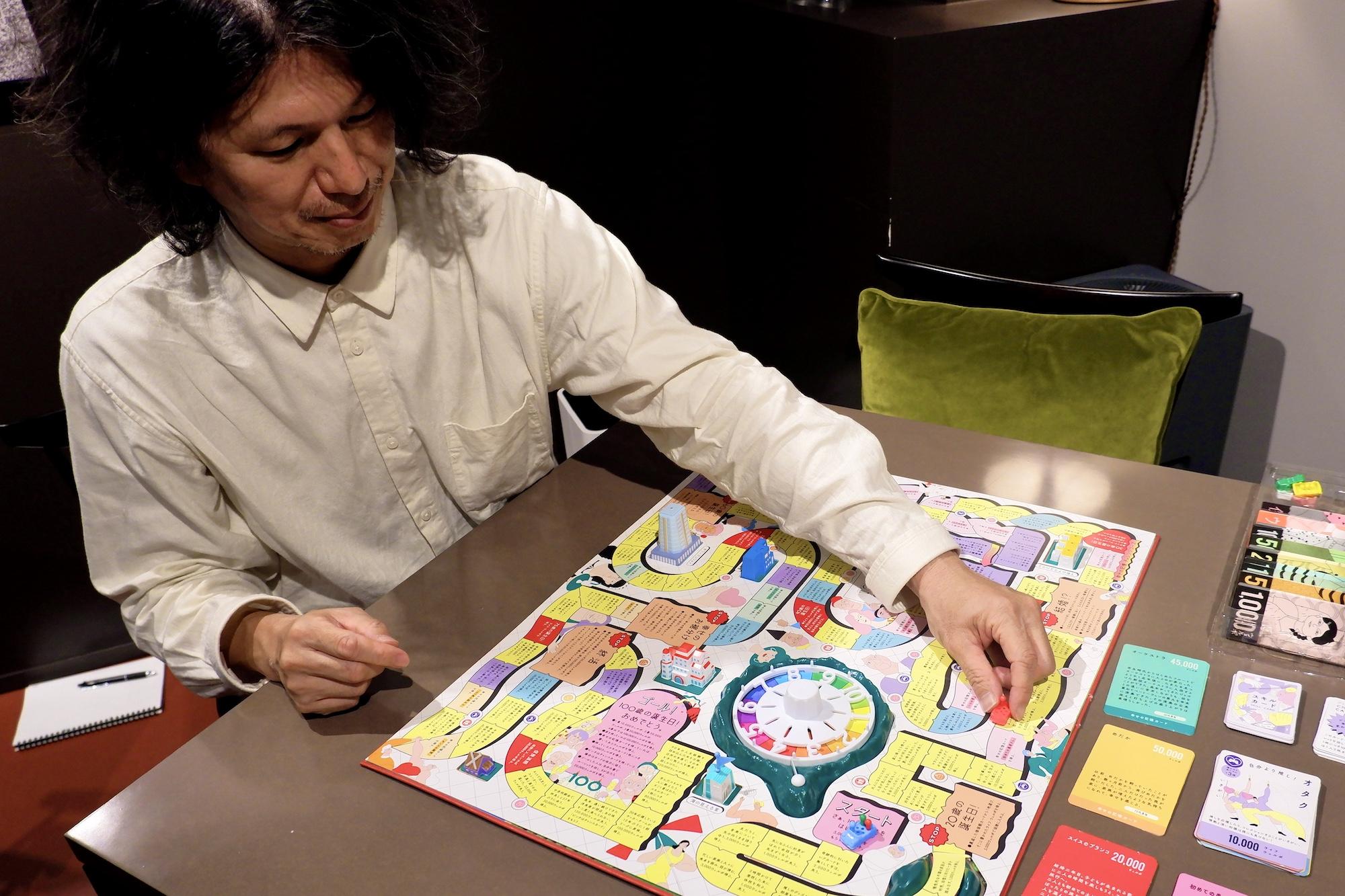 人生ゲーム新作は「億万長者を目指さない」。通貨は“幸福度”、実話が