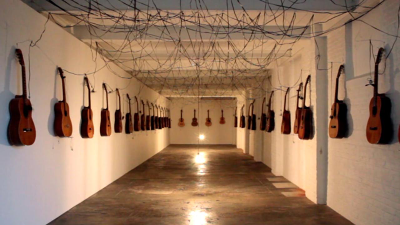 廊下に並べられた40本のギターが起こすイリュージョン