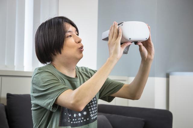 Oculus Quest 2のヘッドセットを持つ