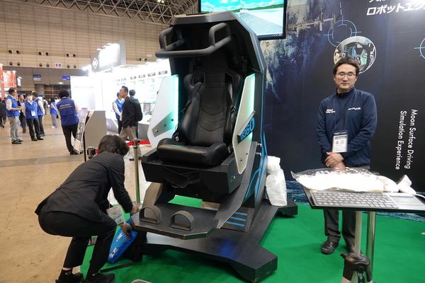 Walkerというパソコン型の乗り物です。特殊なセンシング技術の乗り物です。 宇宙で作業すると乗り物酔いすることが分かった、月面ドライブ体験