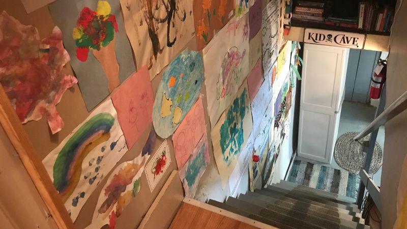 地下室に続く階段の壁に子どもの絵がたくさん