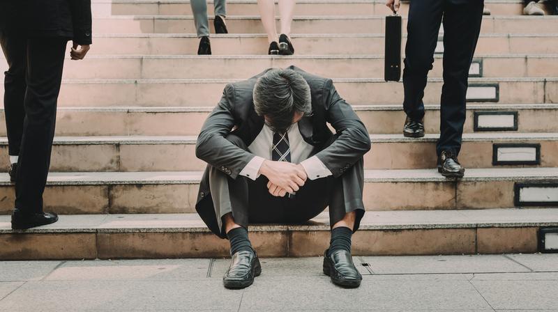 階段で座り込み落ち込む男性