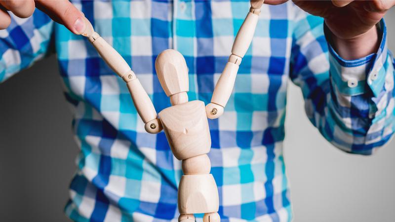 男性が人形を持っているところ
