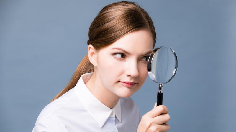 虫眼鏡を覗いて観察する女性