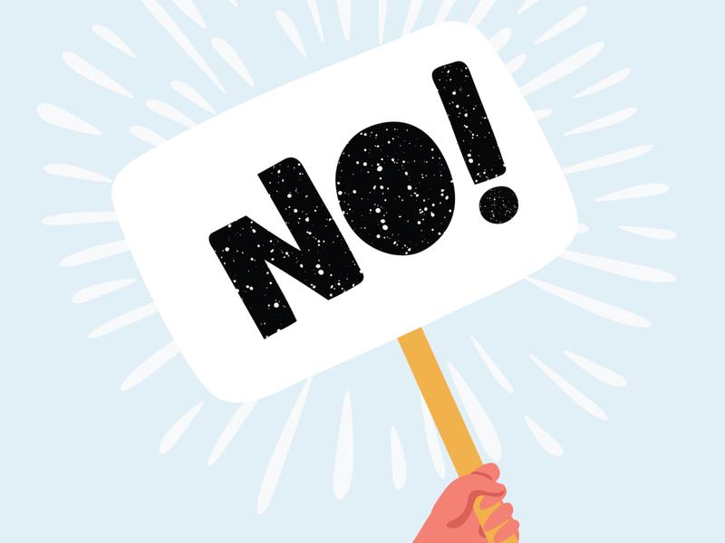 「NO!」と書かれたプラカードを掲げる様子