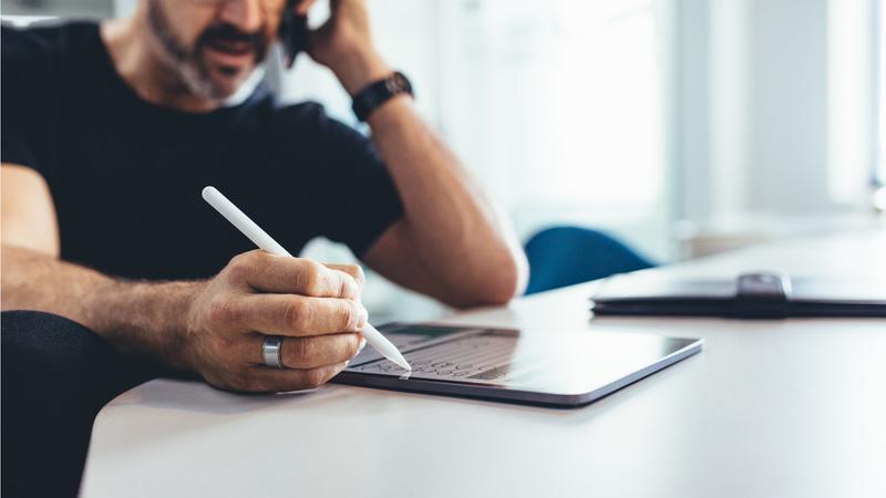 通話しながらタブレット操作する男性