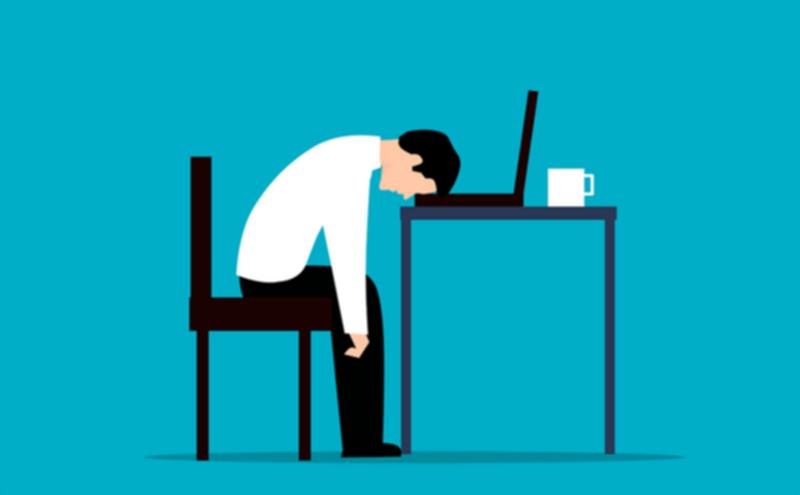 机に頭をうなだれている人のイラスト