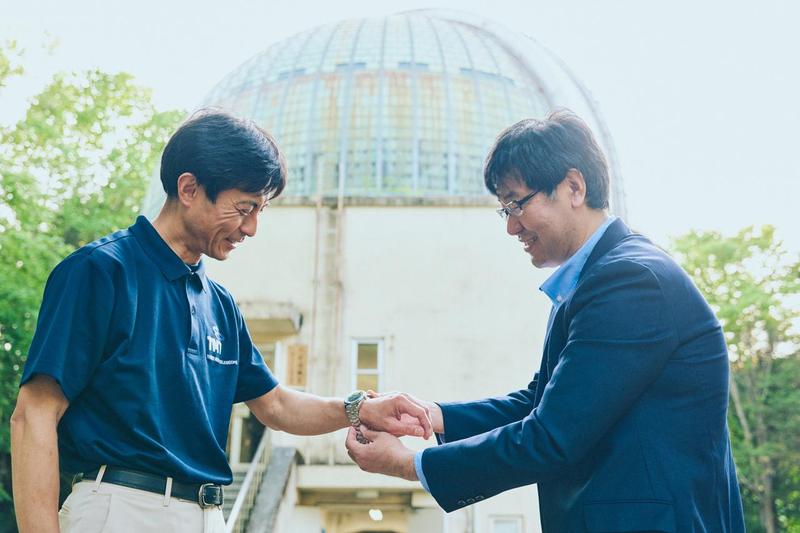 青木教授に時計の装着感を聞く、カンパノラ チーフデザインマネージャーの榎本信一さん(右)。