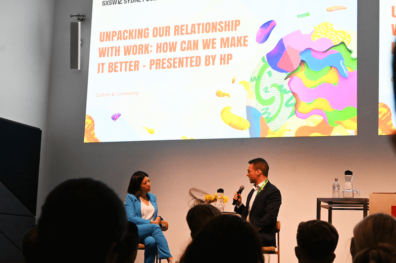 「UNPACKING OUR RELATIONSHIP WITH WORK(仕事とわたしたちの関係を明らかにする)」左から、SHE LOVES TECH の共同創業者で心理学者のリアン・ロバース氏、HPニュージーランドのカントリー・マネージャー、オリバー・ヒル氏。