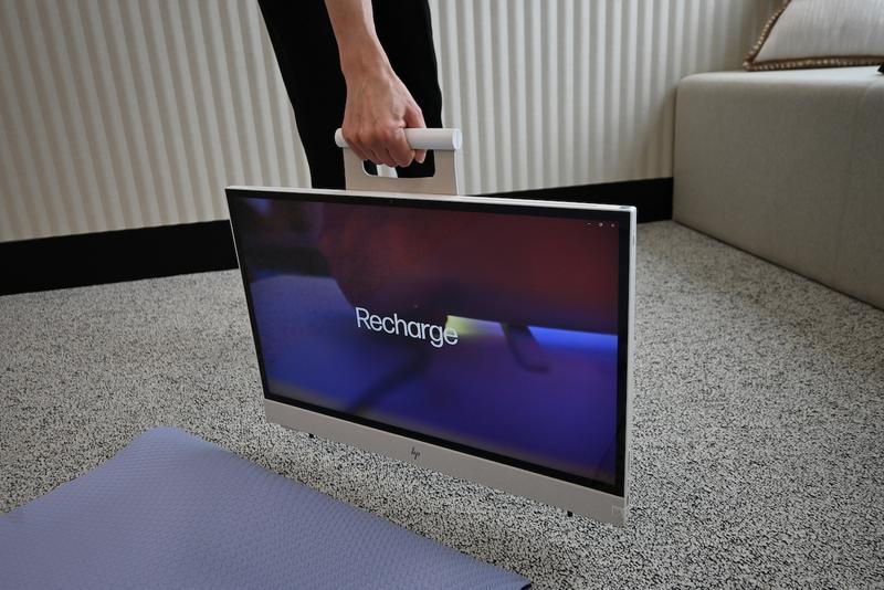 HP ENVY Move All-in-One 24の利用シーン例。上部のハンドルを持って軽々と持ち運び可能。リビングでのヨガレッスンからキッチンでの料理動画視聴まで使い勝手の良さ抜群。