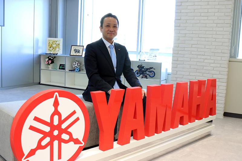 ヤマハロボティクスの中村亮介社長。オフィスの入口にはヤマハ発動機のロゴや、バイクの模型も。
